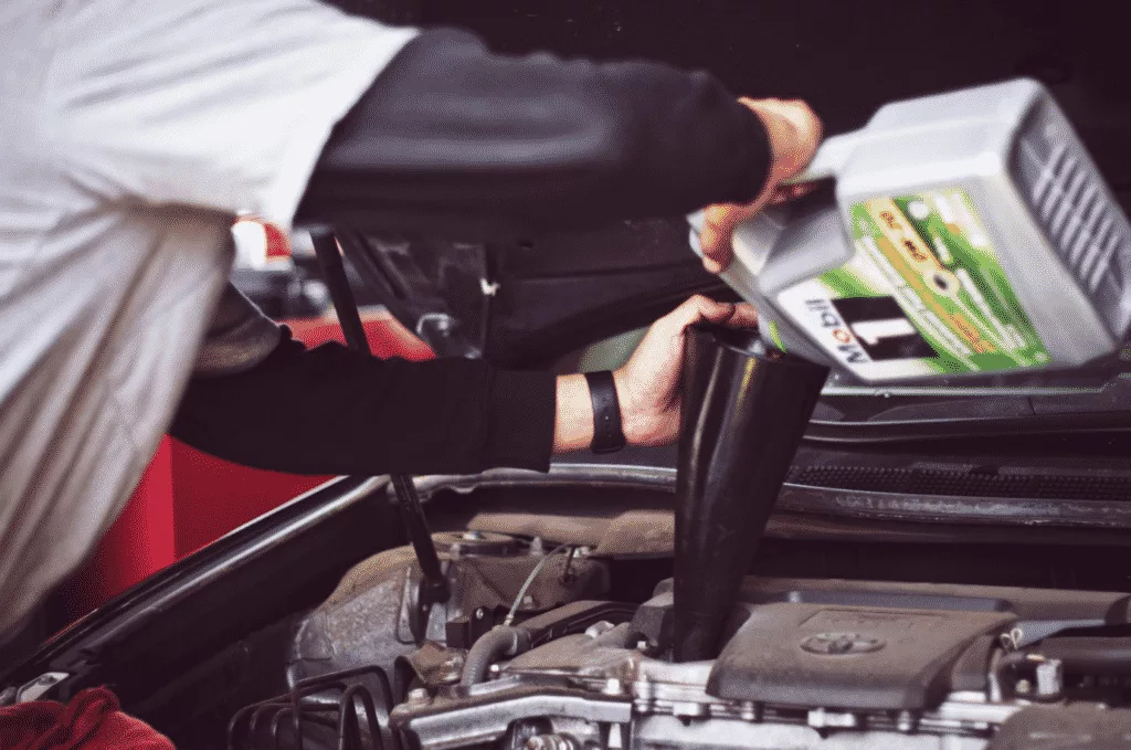 professional lube technician adding oil